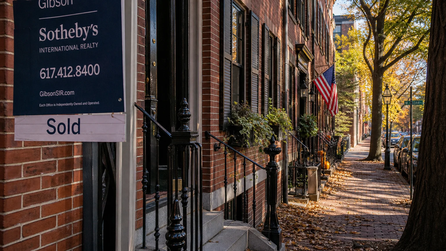A historic brick street in Massachusetts with a 'Sold' sign on a townhouse.